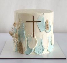 a white cake with blue frosting and a cross on top