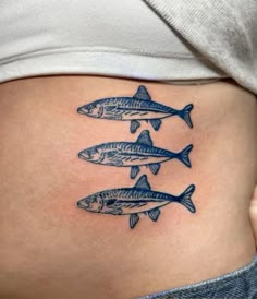 a woman's stomach with three fish tattoos on her belly and the bottom part of her stomach