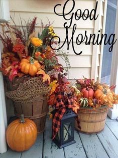 two baskets filled with pumpkins and gourds sitting on a porch next to a sign that says good morning