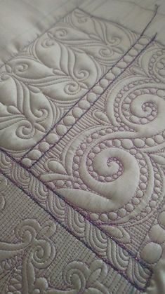 an embroidered quilted bed spread with white thread