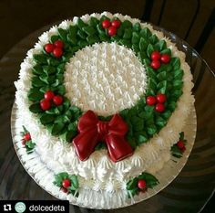 a cake decorated with holly and red berries on top of a glass platter that says cake inspiration