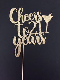 a cake topper that says cheers twenty years on it with the number twenty in gold glitter