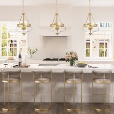 a white kitchen with gold bar stools next to the island and countertop area