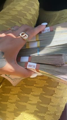 a person with tattoos on their hands holding stacks of papers in each other's hand