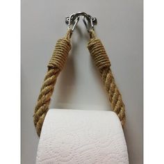 a white toilet paper holder with two roped handles hanging from it's side