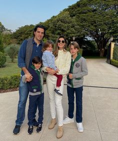 a family poses for a photo in front of some trees