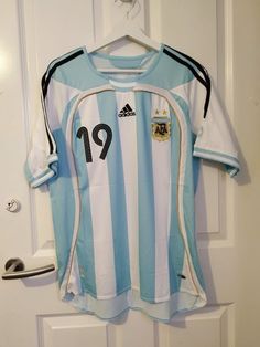 a soccer jersey hanging on a door with the number 19 on it's chest