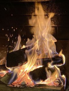 a fire burning in a fireplace with lots of flames