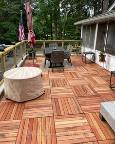 an outdoor deck with table, chairs and umbrellas on the top floor is covered in wood planks