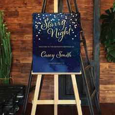 a blue and gold starr night party sign on an easel next to cactus plants