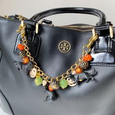 "The newest design addition to the Lenora Dame purse charm collection and this season's newest staple accessory, the Black Cat Halloween chain bag charm. A designer-looking handbag chain accessory with a touch of whimsical to add your own unique style to a handbag, crossbody, or tote. Crafted in gold-finish metal, that's durable and sturdy with strong trigger clasps on either end. Modern and timeless, the charm will lend an avant-garde touch to any bag. 10.5\" L including trigger clasps. (The purse is for display only) Handmade in the USA." Purse Charms Diy, Cuffs Diy, Charm Bracelet Watch, Key Change, Textures Fashion, Accessorize Bags, Unique Handbag, The Black Cat, Charm Collection