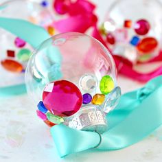 three glass ornaments with colorful beads and bows