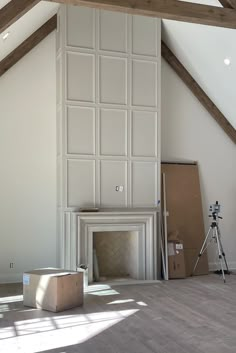 an empty room with white walls and wood floors, including a fireplace in the center