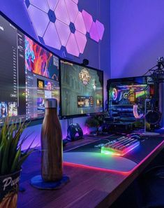 two computer monitors sitting on top of a wooden desk