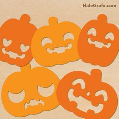 four pumpkin cut outs sitting on top of a wooden surface with the words happy halloween written below them