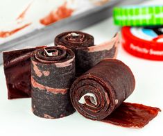 three rolled up pieces of chocolate sitting next to each other on top of a table