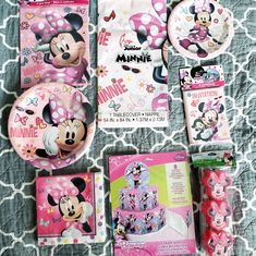 minnie mouse birthday party supplies including plates, napkins and cups on a bed sheet