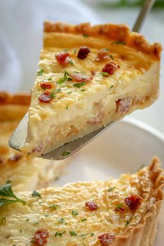 a piece of quiche being lifted from a white plate