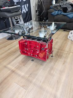 a glass table with red parts on it in the middle of a living room area