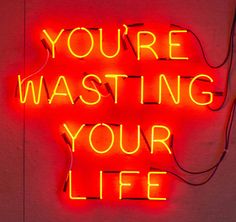 a neon sign that says you're wasteing your life