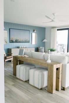 a living room with blue walls and white furniture