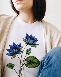 a woman wearing a t - shirt with blue flowers painted on it