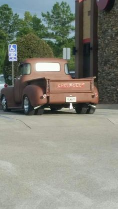 an old truck parked in front of a gas station