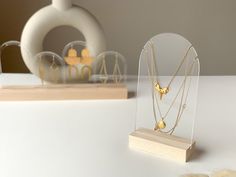 a display case with three necklaces in it on a table next to other jewelry