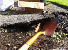 a shovel is laying on the ground next to a box