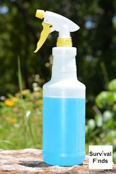 a blue spray bottle sitting on top of a rock