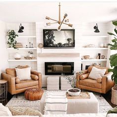 a living room filled with furniture and a flat screen tv mounted on the wall above a fire place