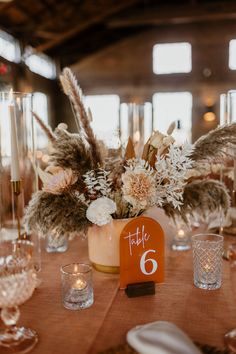 the table is set with flowers and candles