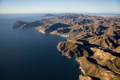 an aerial view of the ocean and mountains