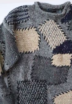 the sweater is made up of many different colors and shapes, including black, white, blue, gray and yellow