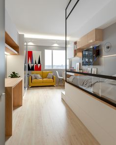 a living room filled with furniture next to a window covered in glass and wooden flooring