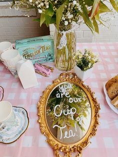 there is a mirror on the table with flowers and other items around it that include cookies