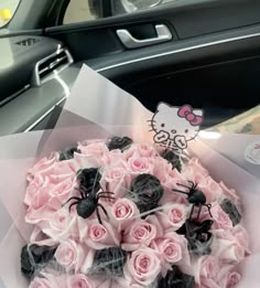 a bouquet of pink roses and black spider in a car