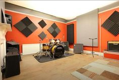 a room with orange walls and guitars on the floor