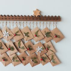 a bunch of brown envelopes are hanging on a wall with holly and snowflakes