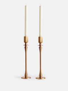 two brass candlesticks with white candles