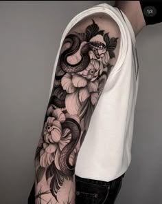 a man's arm with black and white flowers on it