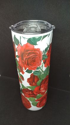 a white and red flowered cup sitting on top of a black table next to a wall