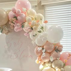 a bunch of balloons that are in the shape of an arch with flowers on it