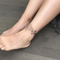 a woman's foot with a flower tattoo on her left ankle and the bottom part of her leg