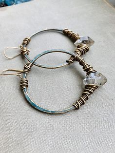 Large 2” brass hoops have been hammered and oxidized with a grunge dark turquoise patina and hand wrapped with dark herkimer diamonds & brass wire. Each hoop dangles 2.5” from 14k goldfill earwires. Handmade in NY Wire Spiral, Jewels Diy, Hammered Jewelry, Wire Earring, Wire Wrapped Jewelry Diy, Bijoux Fil Aluminium, Metalsmithing Jewelry, Boho Crystal, Wire Jewelry Designs