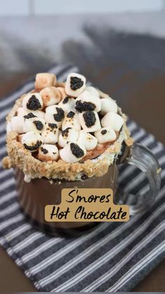 s'mores hot chocolate in a glass mug on a striped napkin with the words smores hot chocolate above it