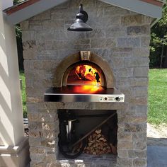 an outdoor pizza oven with firewood in the front and wood on the outside side