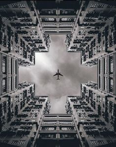 an airplane is flying through the sky over some buildings