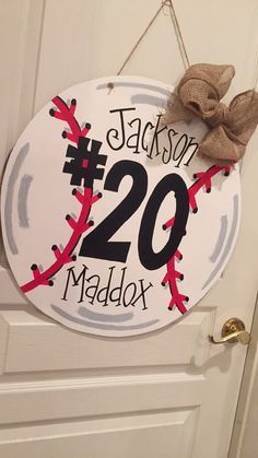 a baseball themed door hanger with the number twenty two in front of it and a bow