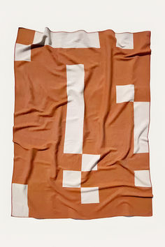 an orange and white checkered blanket on a white background